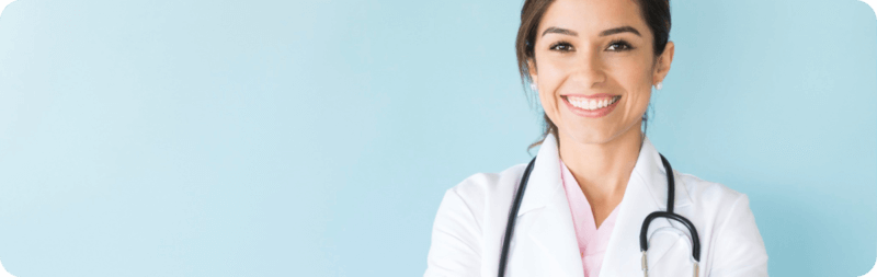a smiling woman doctor in white lab coat