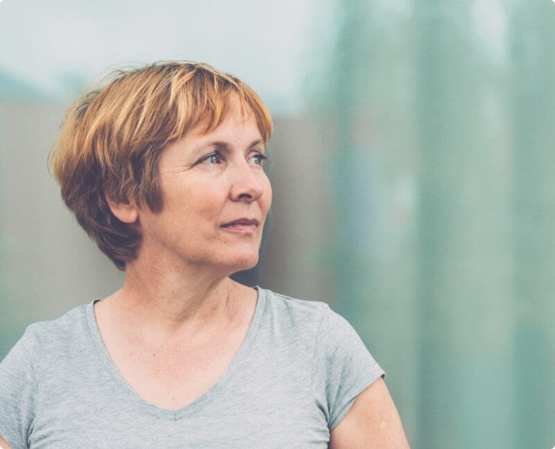 older woman with short hair looking off in the distance