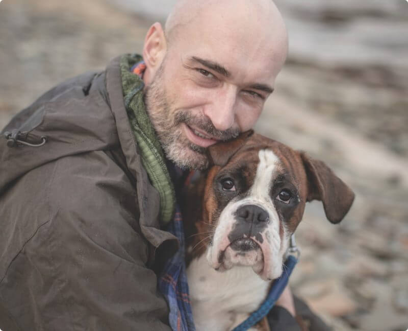 a man hugging his dog and smiling