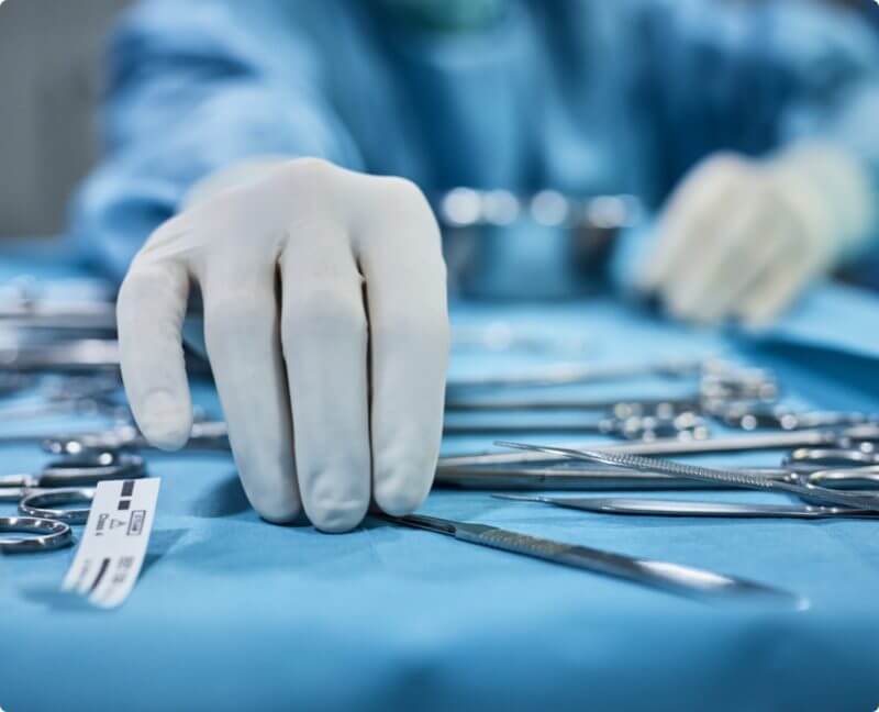 surgeon reaching for surgery tools