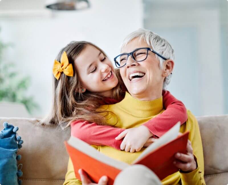 women with intrathecal baclofen pump and granddaughter reading a book together